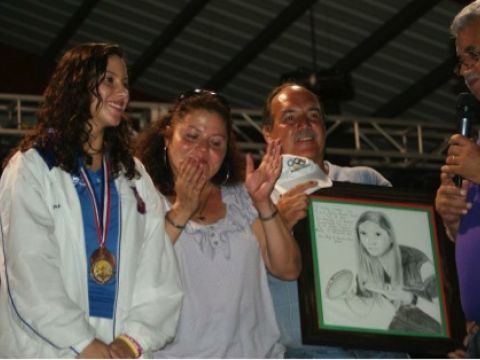 Carelyn recibiendo de manos del Alcalde Hon. Jorge “Georgie” González Otero un afiche mostrando con su foto junto a Carelyn están sus padres Luz. E. Lugo y René Cordero.